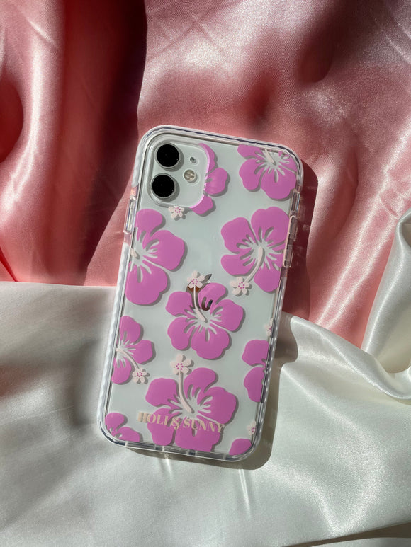 Telefon iPhone i przezroczyste etui z nadrukiem w różowe kwiaty hibiskusy.